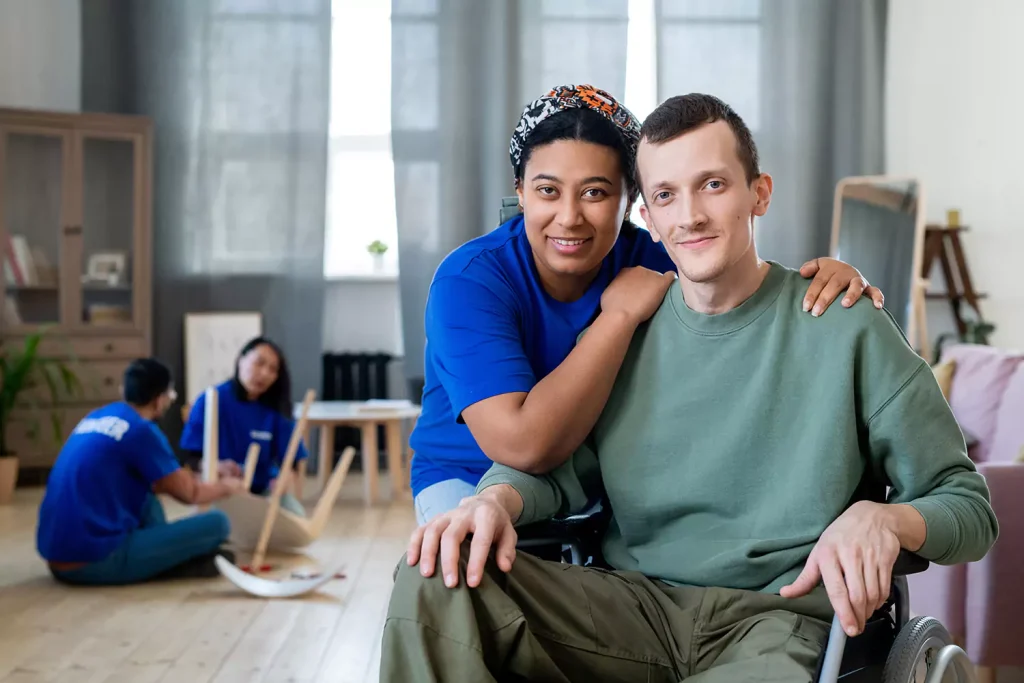 Happy nurse with disabled man in wheelchair