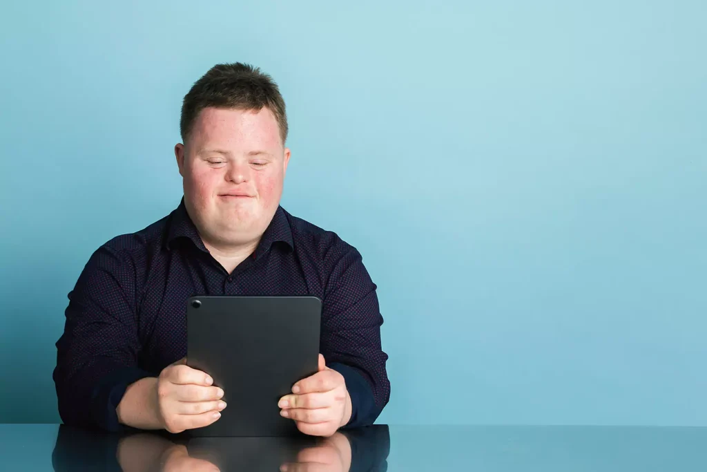Disabled man using iPad to contact Open Arms Care Solutions