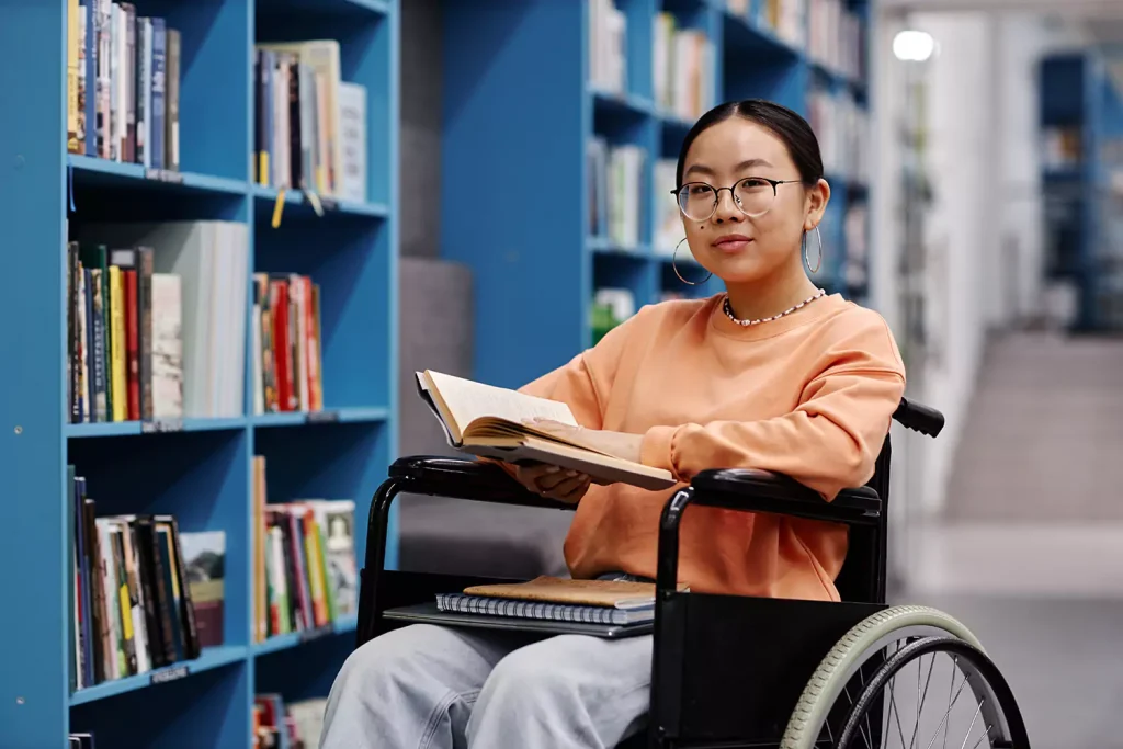 Happy disabled woman in wheelchair smiling at the camera