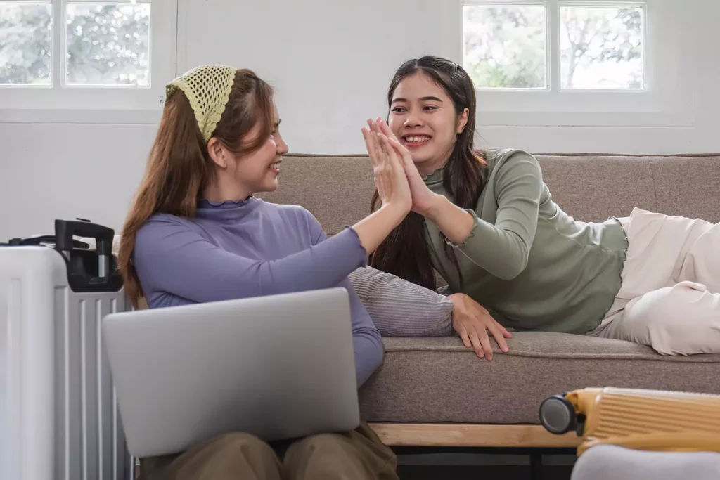 Two friends high fiving while making an NDIS referral
